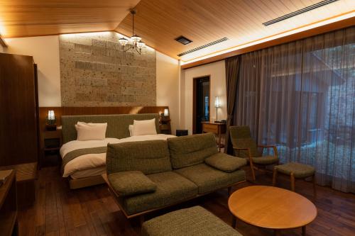 pokój hotelowy z łóżkiem i kanapą w obiekcie Nikko Nishimachi Club w mieście Nikko