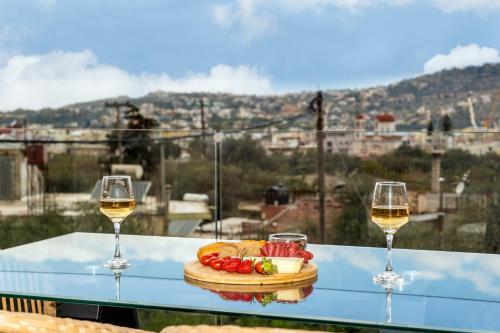 dwa kieliszki wina i talerz jedzenia na stole w obiekcie Sans Souci Home w mieście Suda