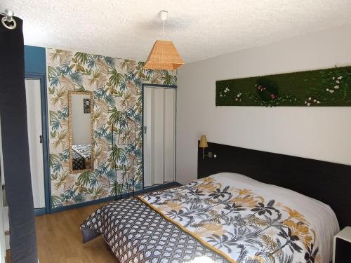 1 dormitorio con cama y pared de flores en Auberge du botaniste en Boissières