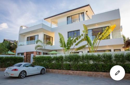 a white car parked in front of a house at Pina Colada in Amphoe Koh Samui