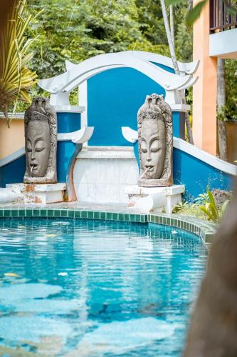 two statues sitting next to a swimming pool at Kasalong Resort and Spa Pattaya in Pattaya Central