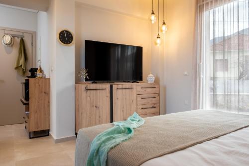 una camera da letto con TV a schermo piatto su un comò in legno di Sans Souci Home a Souda (Suda)