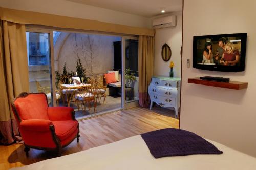 a bedroom with a bed and a chair and a living room at Poetry Building Recoleta in Buenos Aires