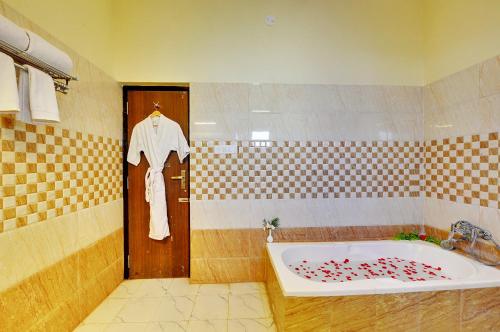 a bathroom with a sink and a bath tub at Padmini Bagh Resort by Inventree, Udaipur in Udaipur