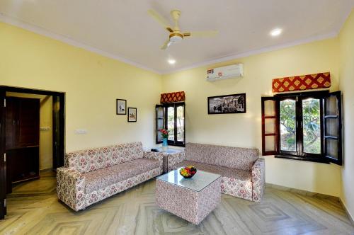 a living room with two couches and a table at Padmini Bagh Resort by Inventree, Udaipur in Udaipur