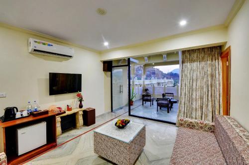 a living room with a flat screen tv and a living room at Padmini Bagh Resort by Inventree, Udaipur in Udaipur