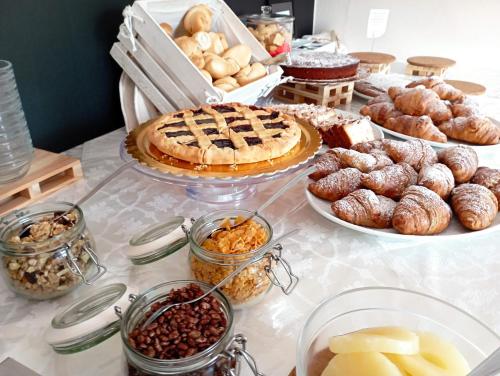 a table with many different types of pastries and pies at Villa Gioiosa Beach & Water Park B&B in Rimini