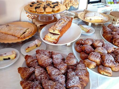 a table with various pastries and cakes and pies at Villa Gioiosa Beach & Water Park B&B in Rimini