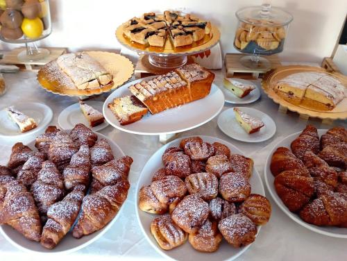 a table full of different types of pastries and cakes at Villa Gioiosa Beach & Water Park B&B in Rimini