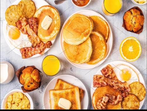 a table topped with plates of breakfast foods at The Bella Vista -Traveler's choice awarded in New Delhi