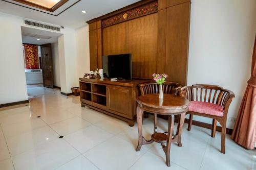 a living room with a table and a television at Kasalong Resort and Spa Pattaya in Pattaya Central