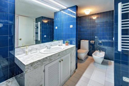 uma casa de banho azul com um lavatório e um WC em SeaHomes Vacations - MARINA BLUE in a exclusive place em Blanes