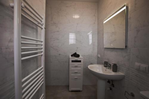 a white bathroom with a sink and a mirror at Villa Fortuna in Chania