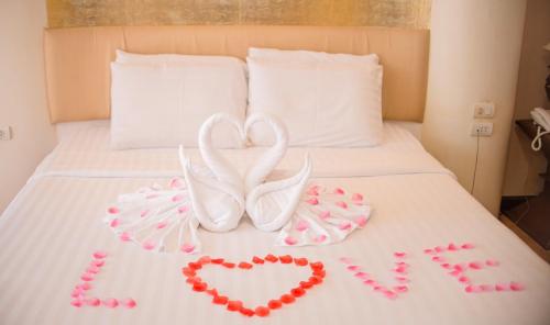 a bed with two hearts and two decorations on it at Kasalong Resort and Spa Pattaya in Pattaya Central