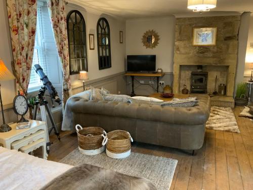 a living room with a couch and a fireplace at Bird In Bush Elsdon in Elsdon