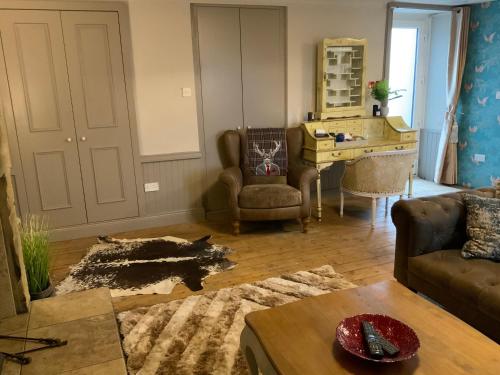 a living room with a couch and a table and a desk at Bird In Bush Elsdon in Elsdon