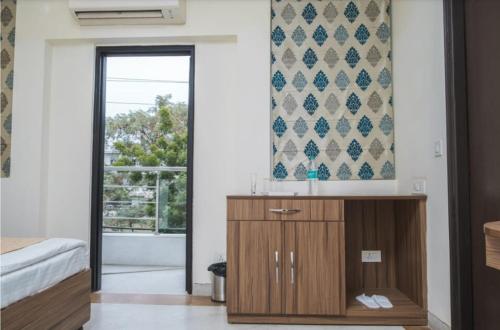 a bedroom with a wooden cabinet and a window at Hotel Leaf 9, Cyber City near Ambience Mall in Gurgaon