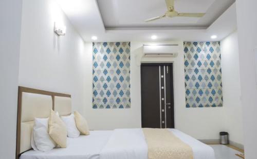 a bedroom with a bed and a ceiling fan at Hotel Leaf 9, Cyber City near Ambience Mall in Gurgaon