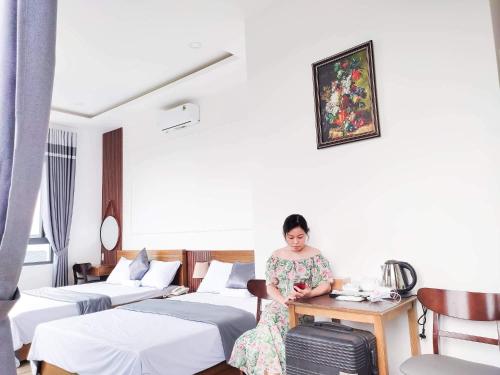 a woman sitting at a table in a hotel room at Hotel Hoa Nắng in Bao Loc