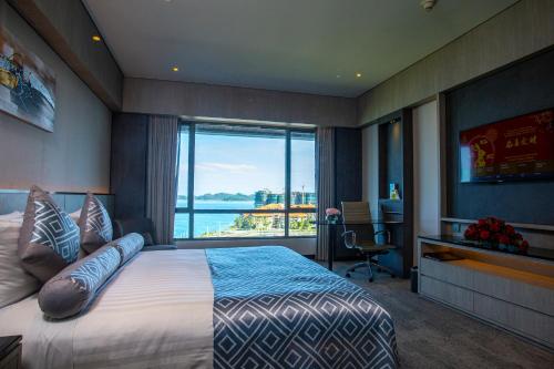 a bedroom with a large bed and a large window at The Pacific Sutera Hotel in Kota Kinabalu