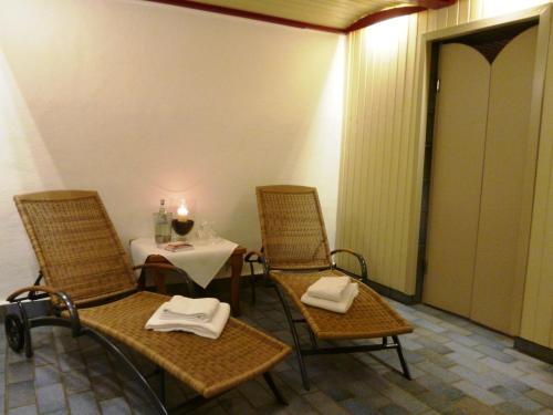 a room with a table and chairs with a table and a candle at Simones Hotel Fürstenhof in Landshut