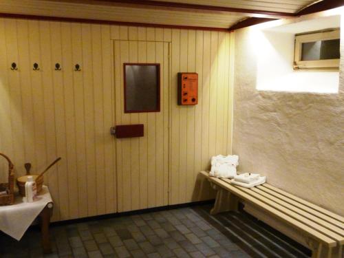 a room with a bench and a door and a table at Simones Hotel Fürstenhof in Landshut