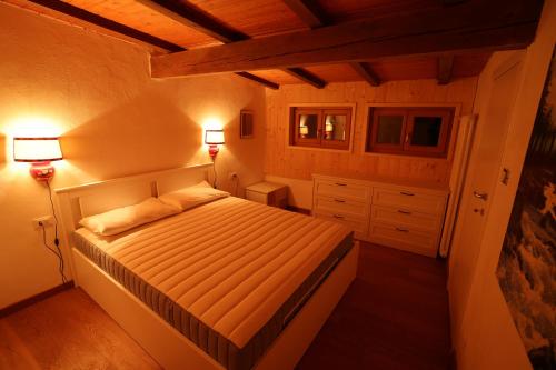 a bedroom with a bed and two lamps in it at Casa Latemar in Moena