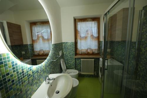 a bathroom with a sink and a toilet and a mirror at Casa Latemar in Moena