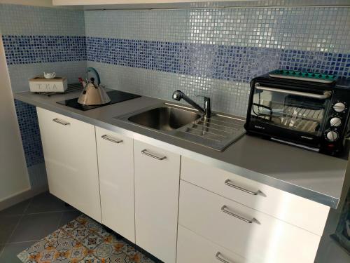 a kitchen with a sink and a toaster oven at Casa Adriana Fronte Mare in Monopoli