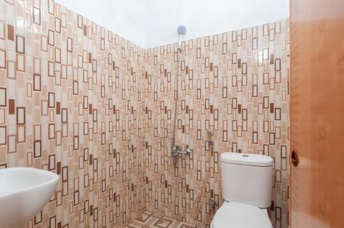 a bathroom with a toilet and a sink at Urbanview Hotel Nisura Homestay Medan by RedDoorz in Sunggal