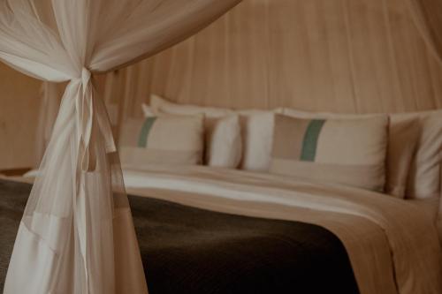 a bed with white pillows and a canopy at The Bean Tree in McGregor