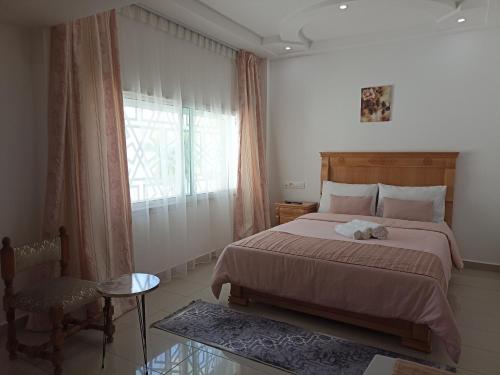 una camera con un grande letto e una finestra di Cozy duplex a Rabat