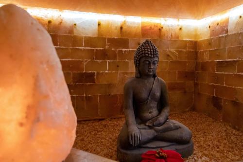 a statue of a buddha sitting in a room at Terra Mia Suite in Catania
