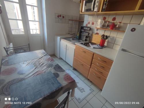a small kitchen with a table and a refrigerator at Studio tout confort- wifi- Gare-Le Train Bleu 1 in Nevers