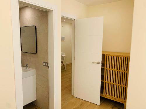 łazienka z umywalką i lustrem na ścianie w obiekcie Alameda Lofts Pontevedra w mieście Pontevedra