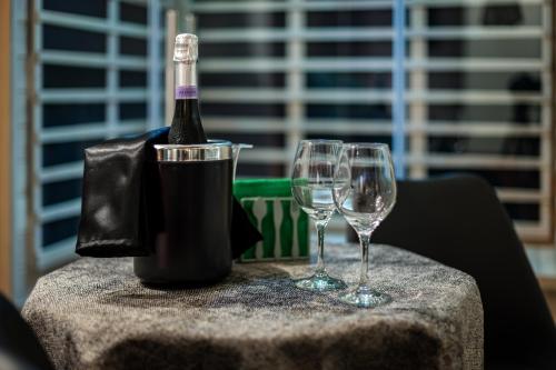 una botella de vino y dos copas de vino en una mesa en Terra Mia Suite, en Catania