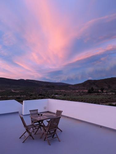 a table and two chairs on a balcony with a sunset at The Bean Tree in McGregor