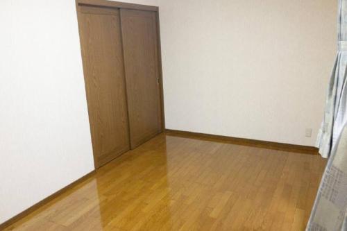 Habitación vacía con 2 puertas y suelo de madera en Guest House Kiyohime, en Tanabe