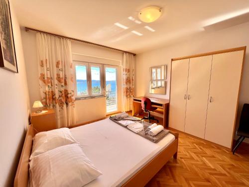 a bedroom with a bed and a large window at Apartments Mare in Dramalj