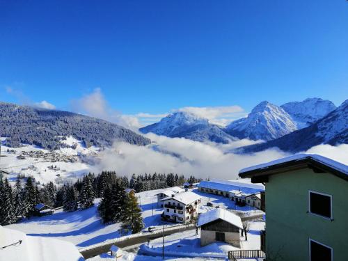 a ski lodge with snow covered mountains in the background at Casa vacanze da Olga in Danta