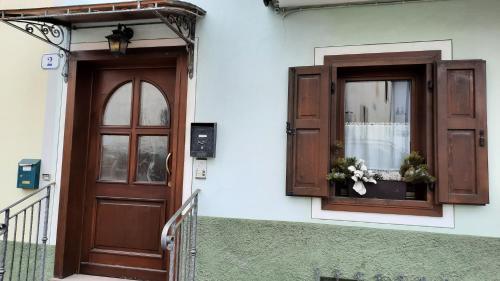 a building with a door and a window with flowers in it at Casa vacanze da Olga in Danta