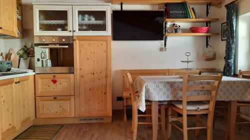 a kitchen with wooden cabinets and a table and chairs at Casa vacanze da Olga in Danta