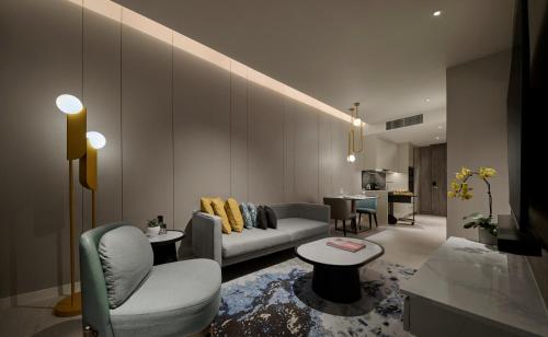 a living room with a couch and a table at Pan Pacific Serviced Suites Kuala Lumpur in Kuala Lumpur