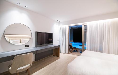 a hotel room with a bed and a mirror at AKASHA Beach Hotel & Spa in Hersonissos