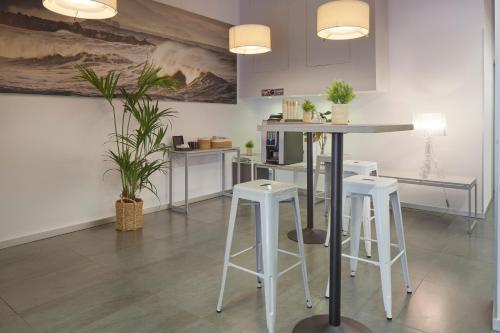 a kitchen with a counter with stools and a table at Welcome Gros Hotel in San Sebastián