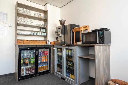 a refrigerator filled with lots of drinks in a room at Hotelletje de Veerman in Oost-Vlieland