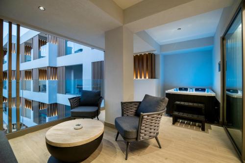 a living room with a table and chairs and a piano at AKASHA Beach Hotel & Spa in Hersonissos