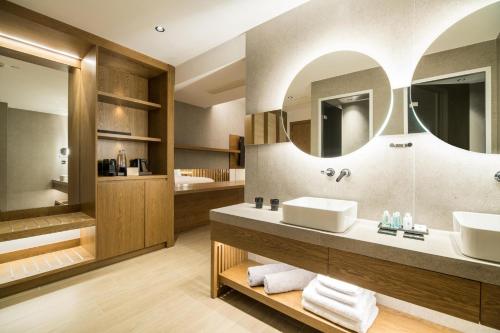 a bathroom with two sinks and a large mirror at AKASHA Beach Hotel & Spa in Hersonissos