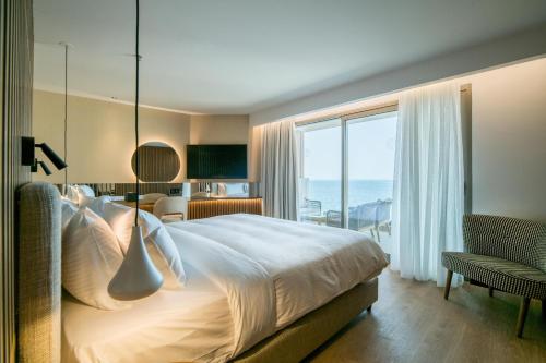 a hotel room with a bed and a large window at AKASHA Beach Hotel & Spa in Hersonissos