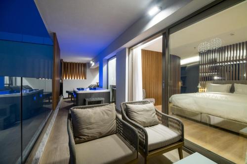 a bedroom with a bed and two chairs and a desk at AKASHA Beach Hotel & Spa in Hersonissos